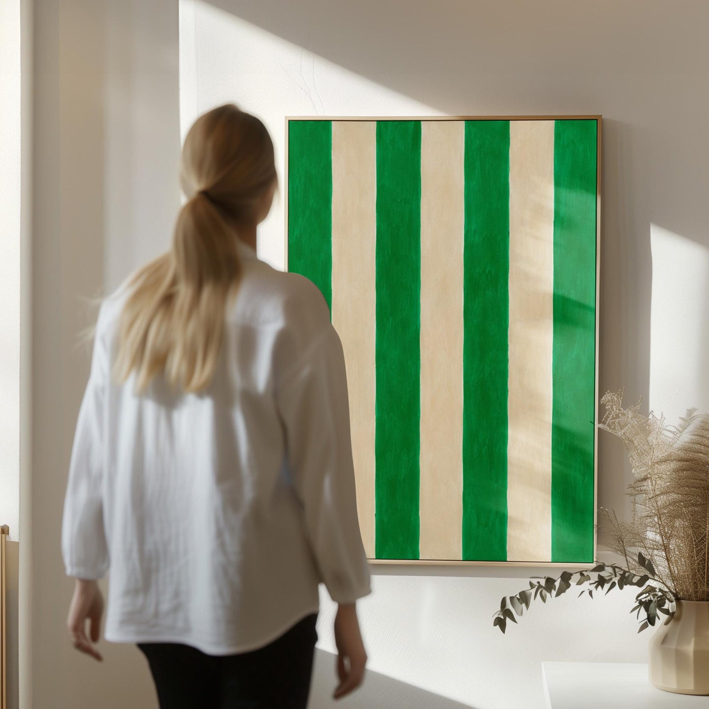 Bold vertical cabana stripes in emerald green and cream, canvas print seen in a warm interior with natural light
