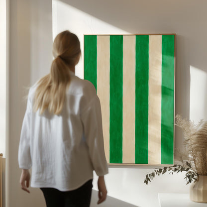 Bold vertical cabana stripes in emerald green and cream, canvas print seen in a warm interior with natural light