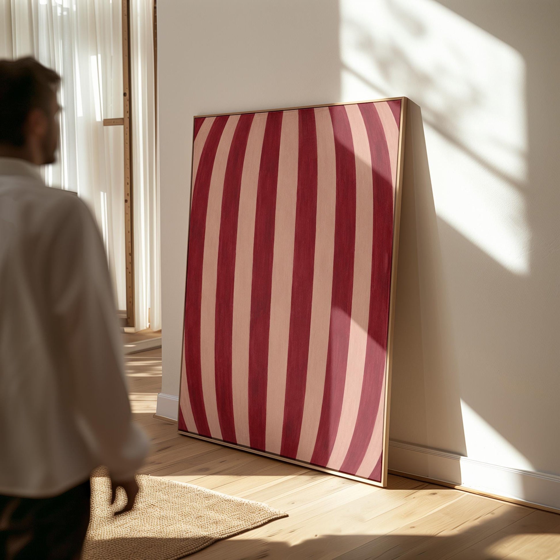 Curved burgundy stripes bowing over blush background, canvas print hanging in a calm, modern living space