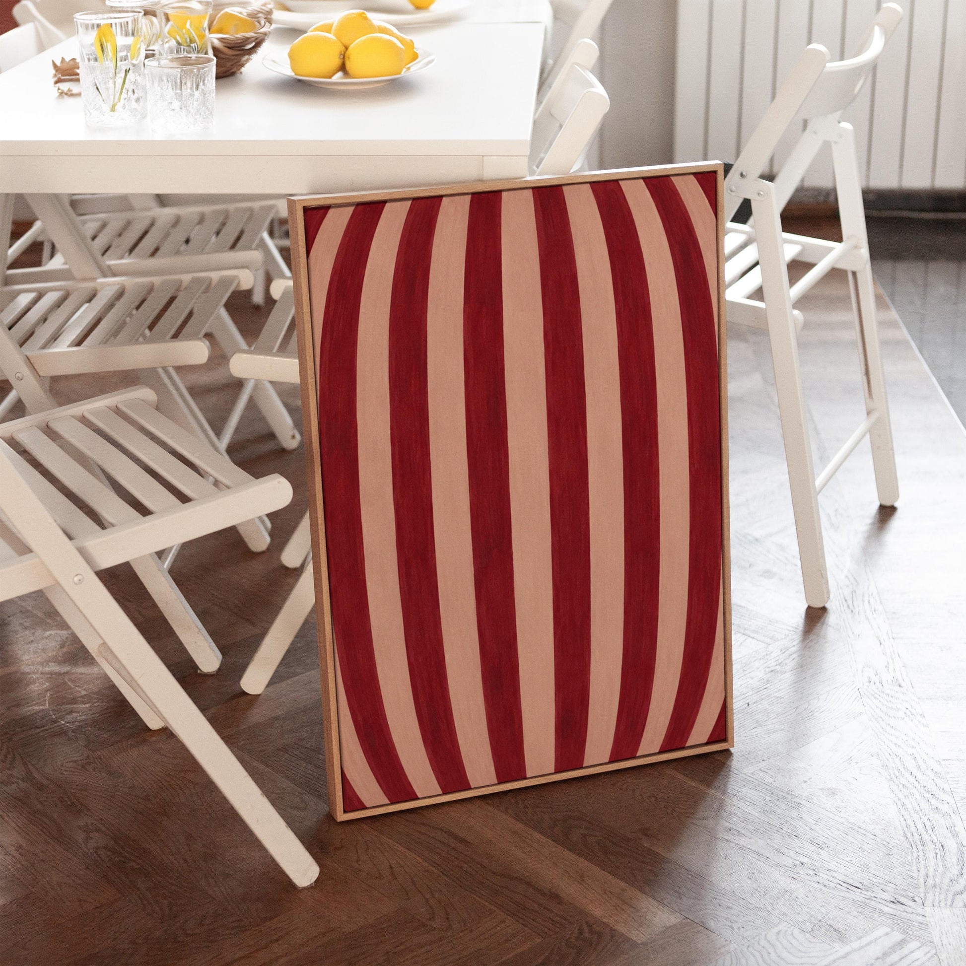 Curved burgundy stripes bowing over blush background, canvas wall art on a quiet wall in a considered interior