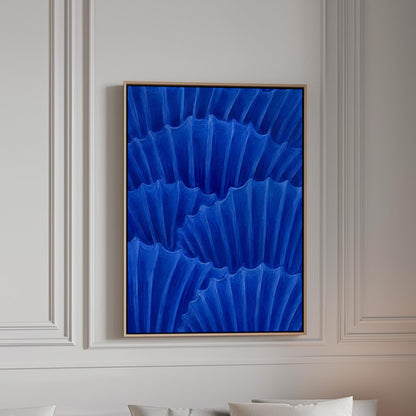 Overlapping pleated fan shapes in deep royal blue, canvas print in a bright room with natural daylight