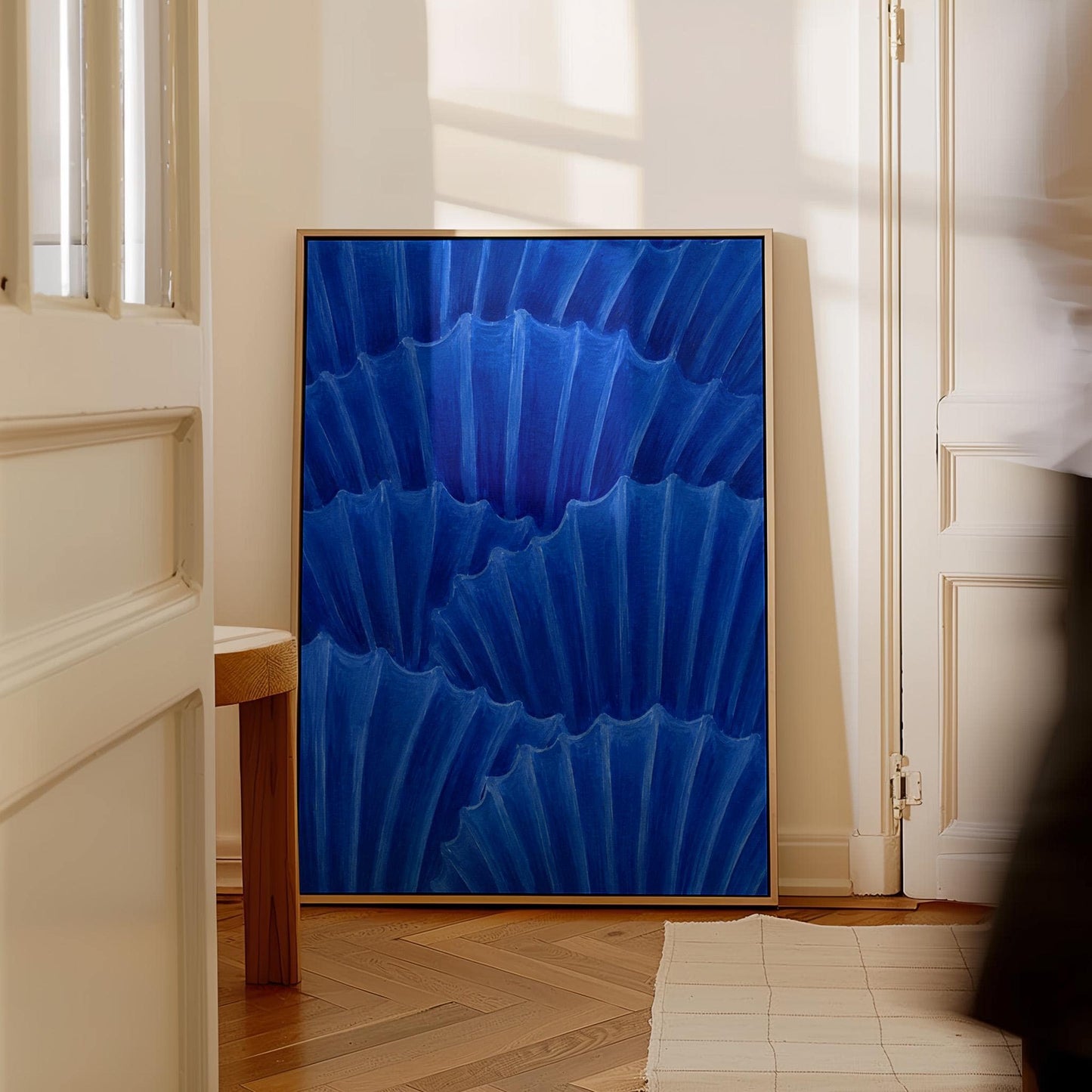 Overlapping pleated fan shapes in deep royal blue, canvas print styled against a soft white wall