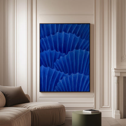 Overlapping pleated fan shapes in deep royal blue, canvas print on a softly lit wall in a calm interior