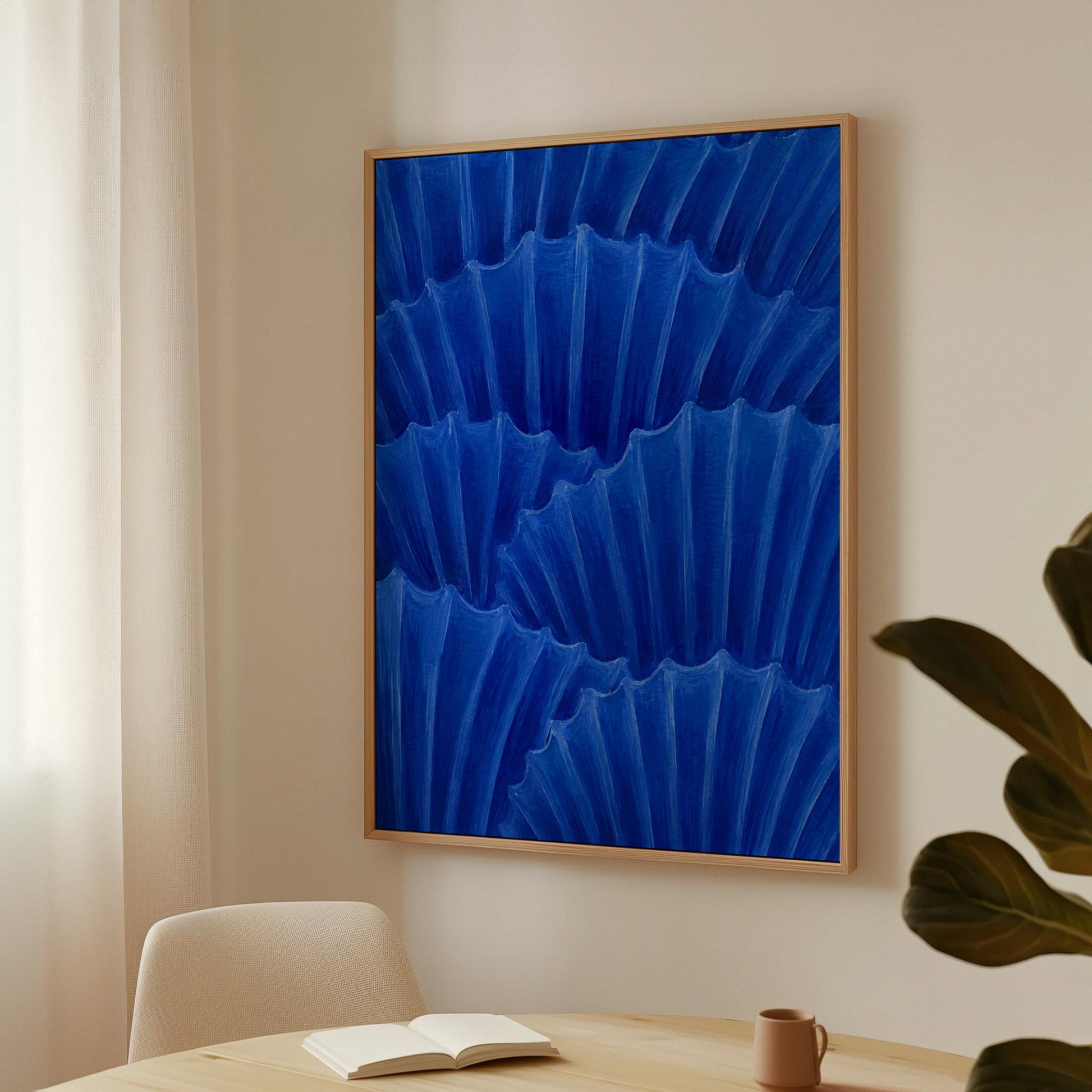 Overlapping pleated fan shapes in deep royal blue, canvas wall art seen in a warm interior with natural light