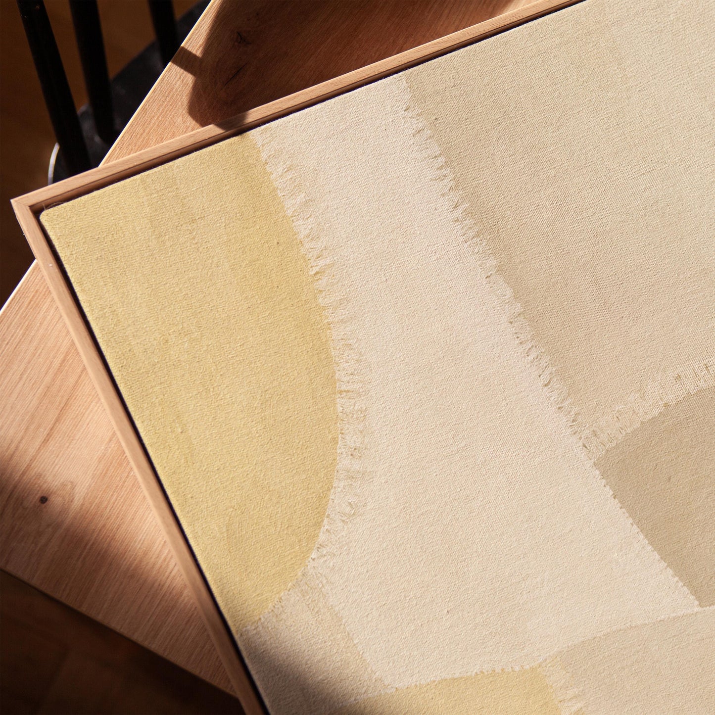 Soft tonal beige blocks joined by delicate stitch lines, canvas print in a warm, minimally styled interior