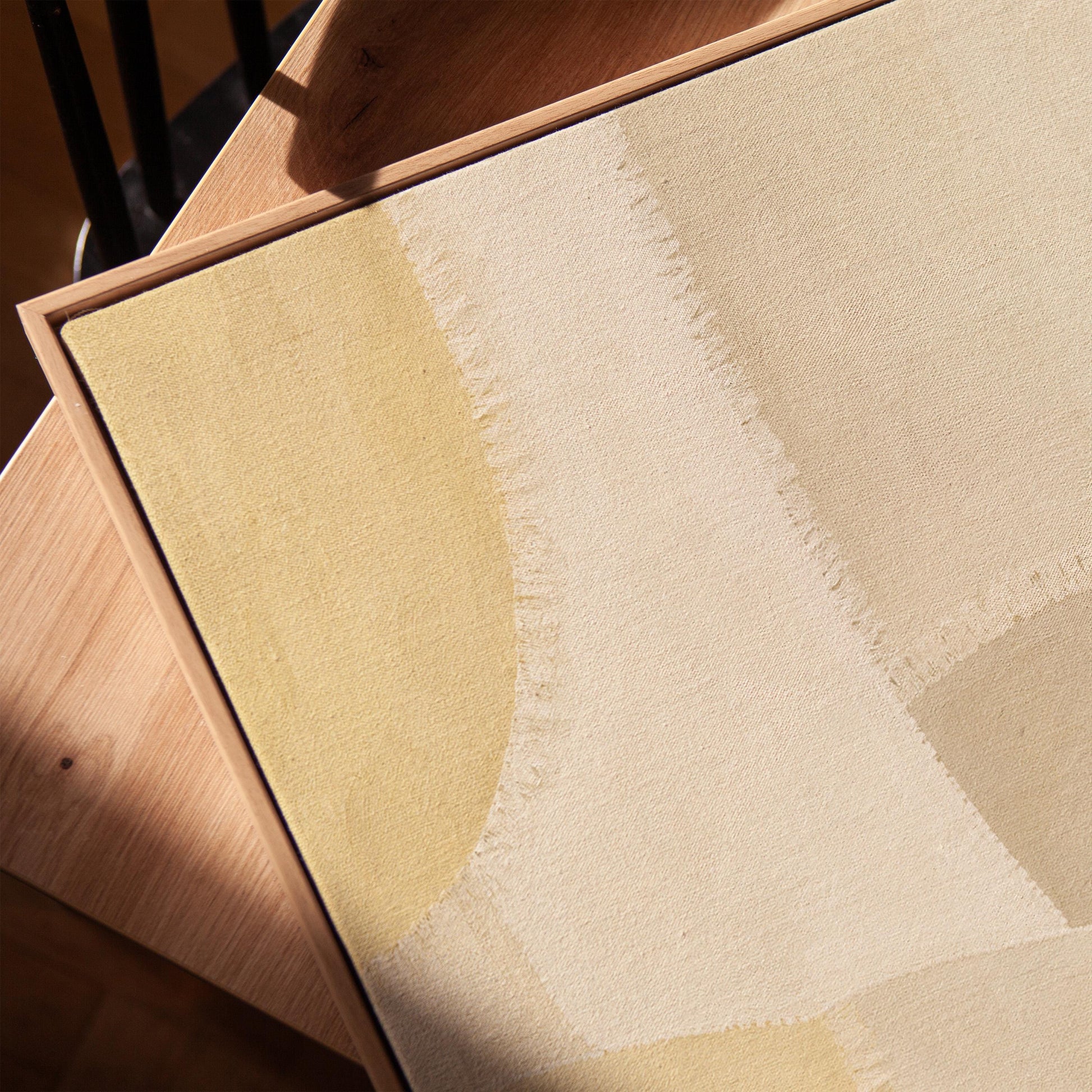 Soft tonal beige blocks joined by delicate stitch lines, canvas print in a warm, minimally styled interior