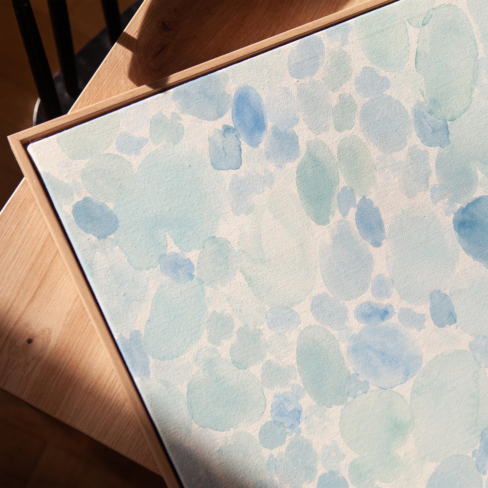 Dappled watercolor petals in light baby blue, canvas print in a warm, minimally styled interior