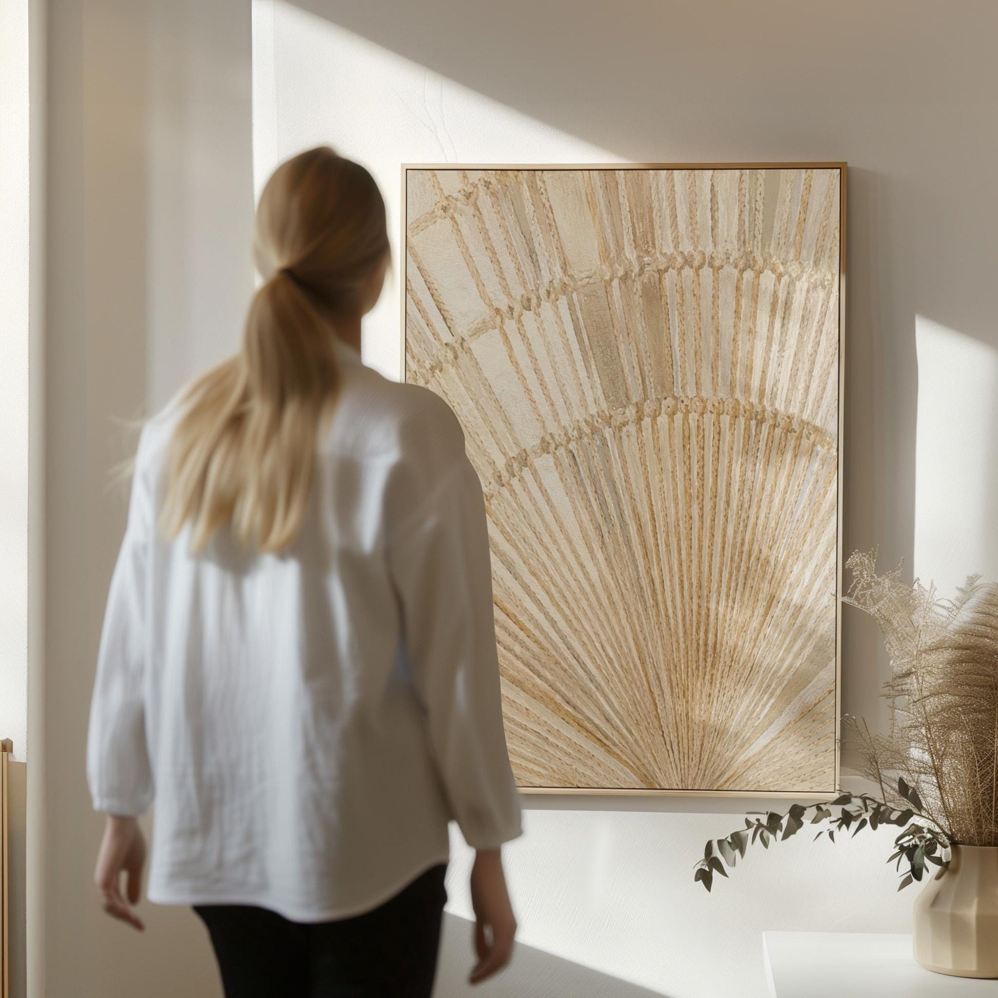 Golden fan palm leaf with radiating rays on cream, canvas print hanging in a calm, modern living space