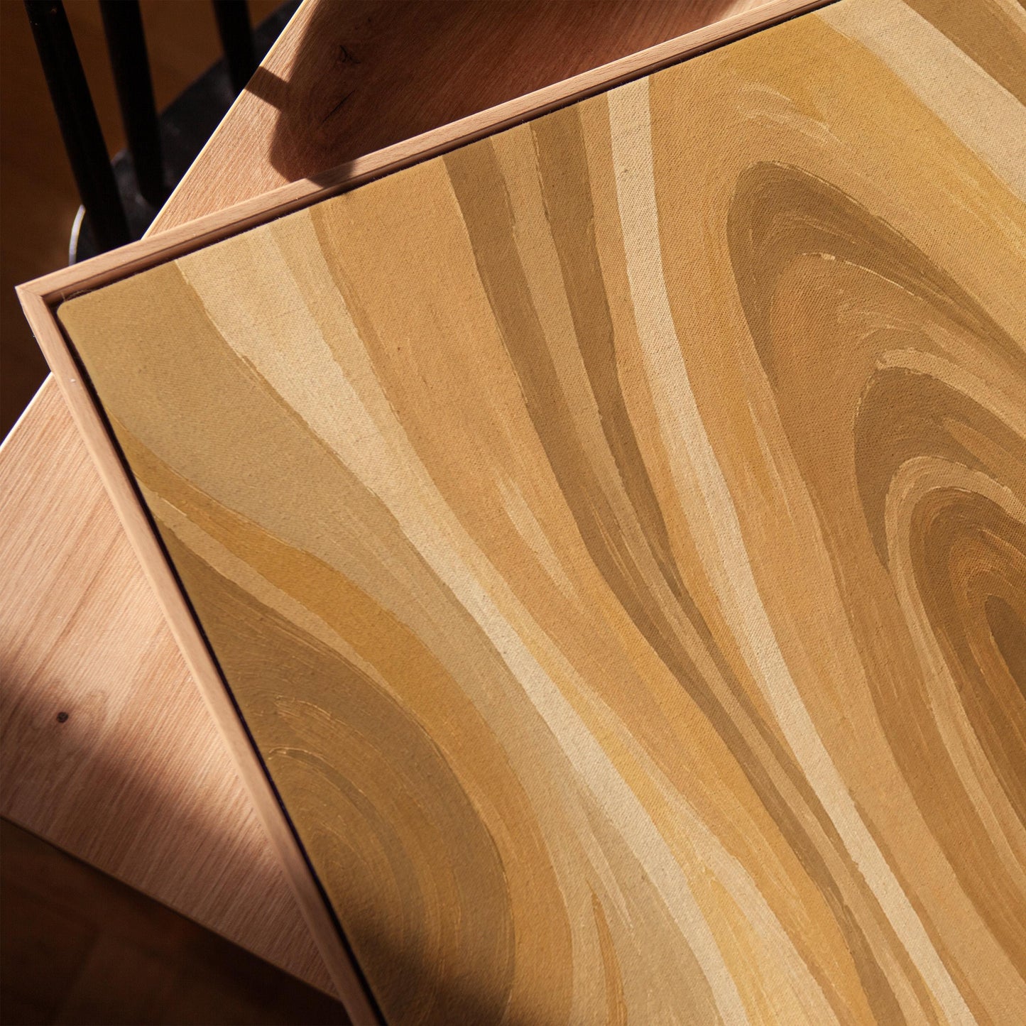 Concentric swirling lines in amber and caramel, canvas print in a warm, minimally styled interior