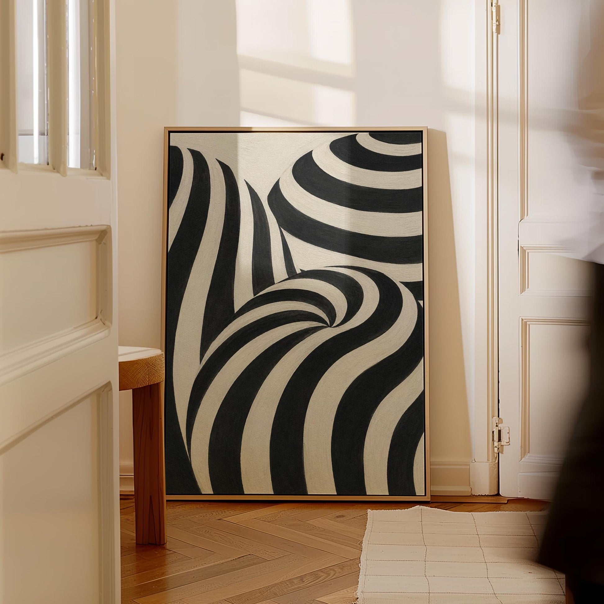 Swirling black and white striped forms, canvas wall art seen in a warm interior with natural light