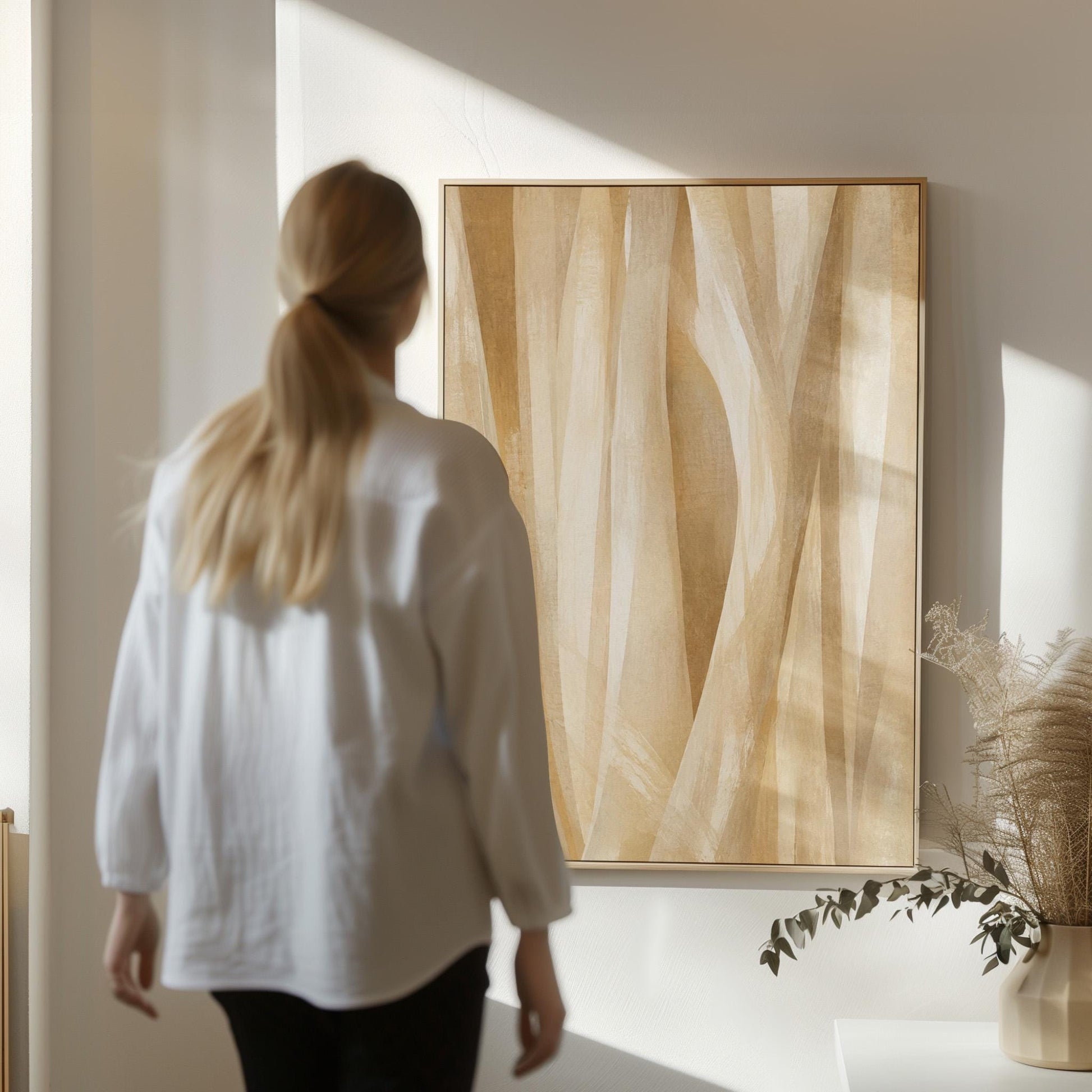 Golden beige ribbon strands flowing diagonally, canvas print displayed on a neutral wall in a styled interior