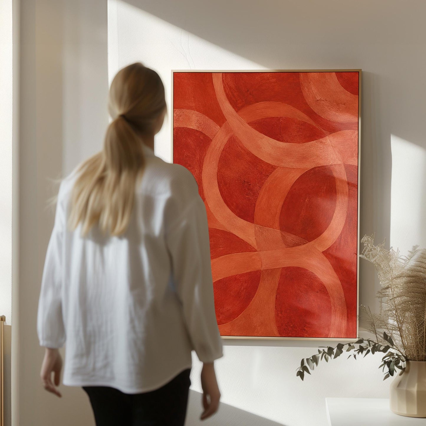 Interlocking loop rings in burnt orange and rust, canvas print hanging in a calm, modern living space