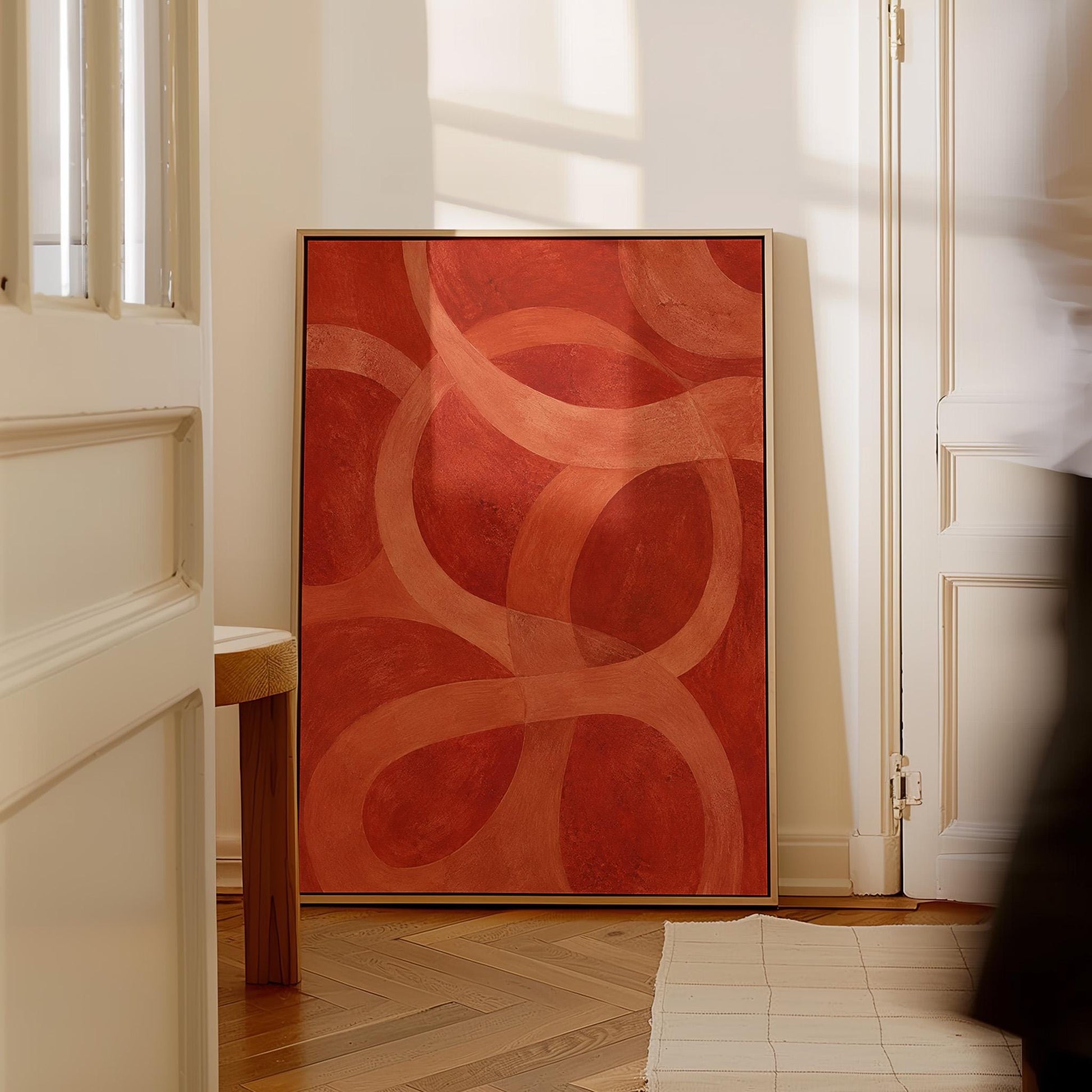 Interlocking loop rings in burnt orange and rust, canvas print on a quiet wall in a considered interior
