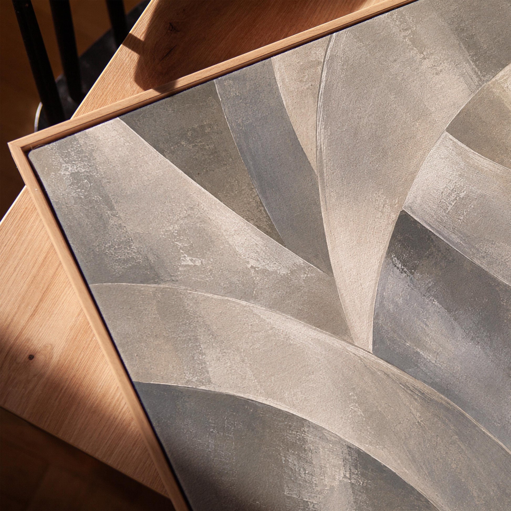 Crossing curved silver bands in graceful motion, canvas print in a warm, minimally styled interior