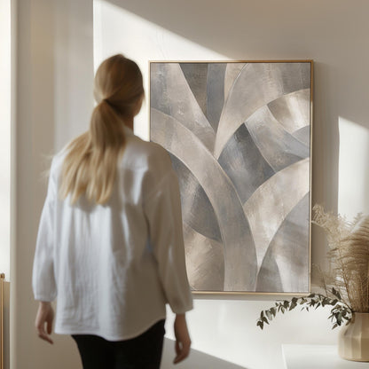 Crossing curved silver bands in graceful motion, canvas print displayed on a neutral wall in a styled interior