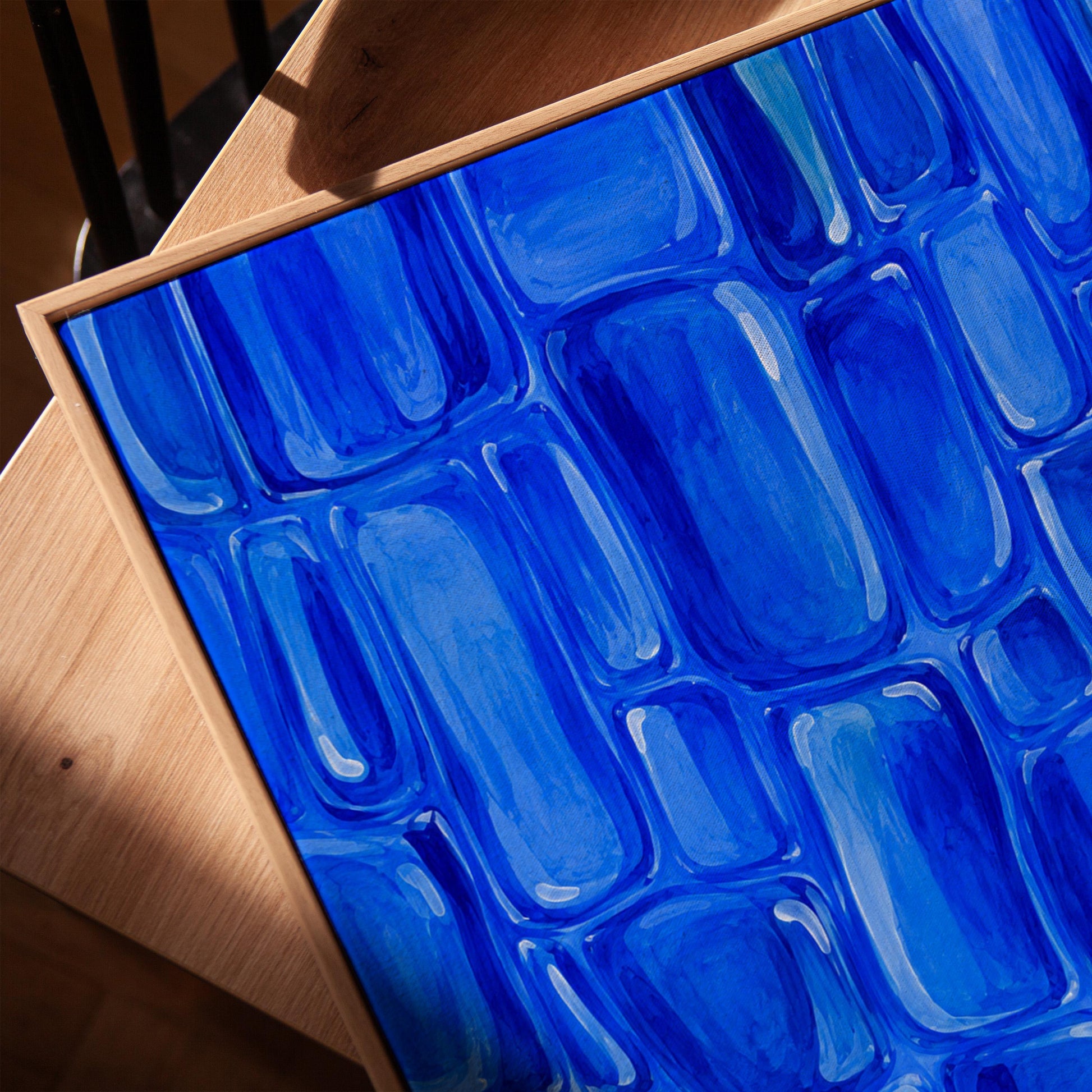Bold cobalt brush stroke blocks in painterly rows, canvas print in a warm, minimally styled interior