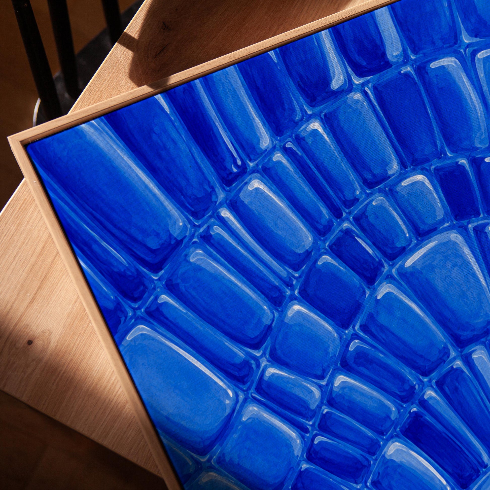 Fan arcs of cobalt mosaic pebbles, canvas print in a warm, minimally styled interior