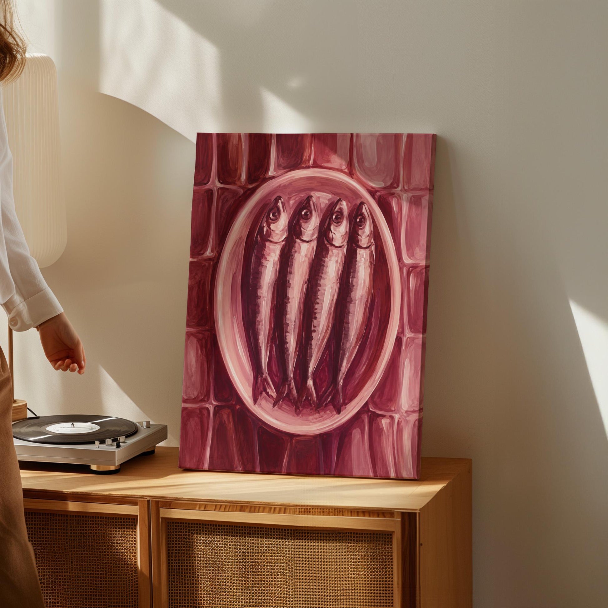 Sardines on oval platter in burgundy monochrome, canvas wall art seen in a warm interior with natural light
