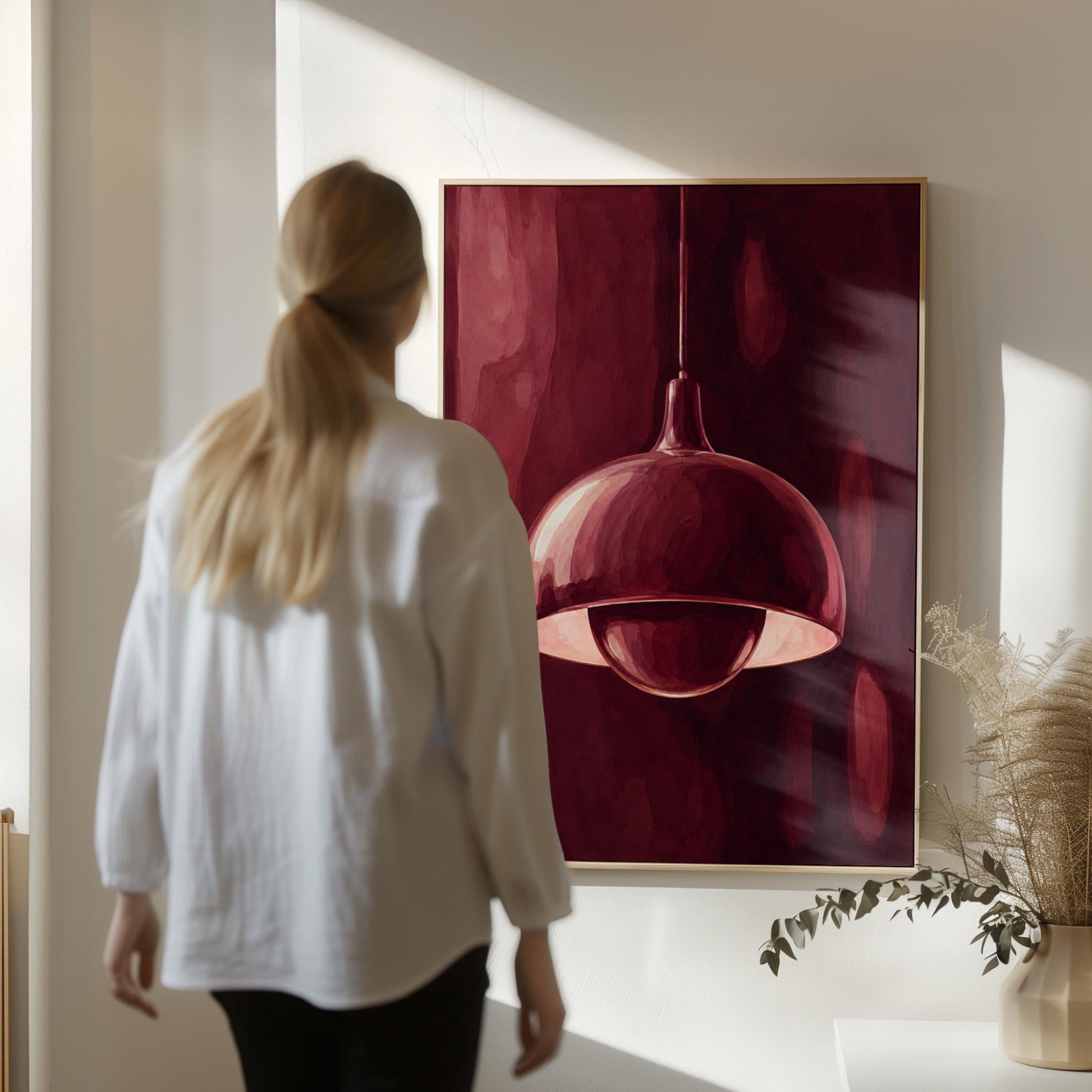 Pendant lamp glowing warmly against burgundy darkness, canvas print seen in a warm interior with natural light