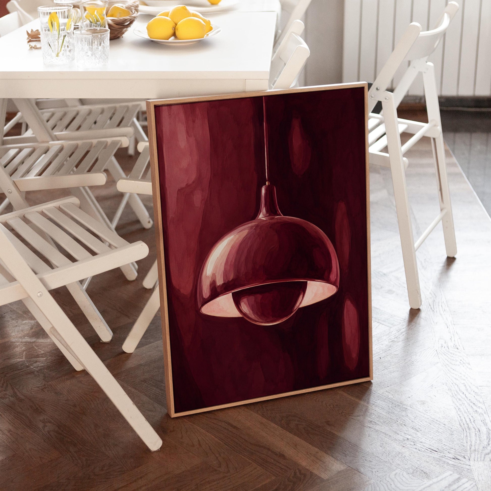 Pendant lamp glowing warmly against burgundy darkness, canvas print on a quiet wall in a considered interior