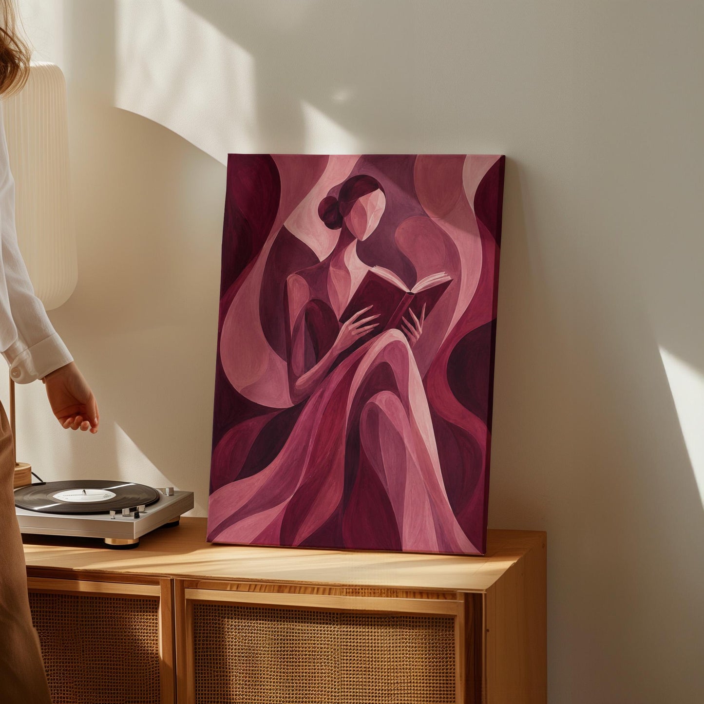Woman reading a book among flowing burgundy drapes, canvas wall art styled against a soft white wall