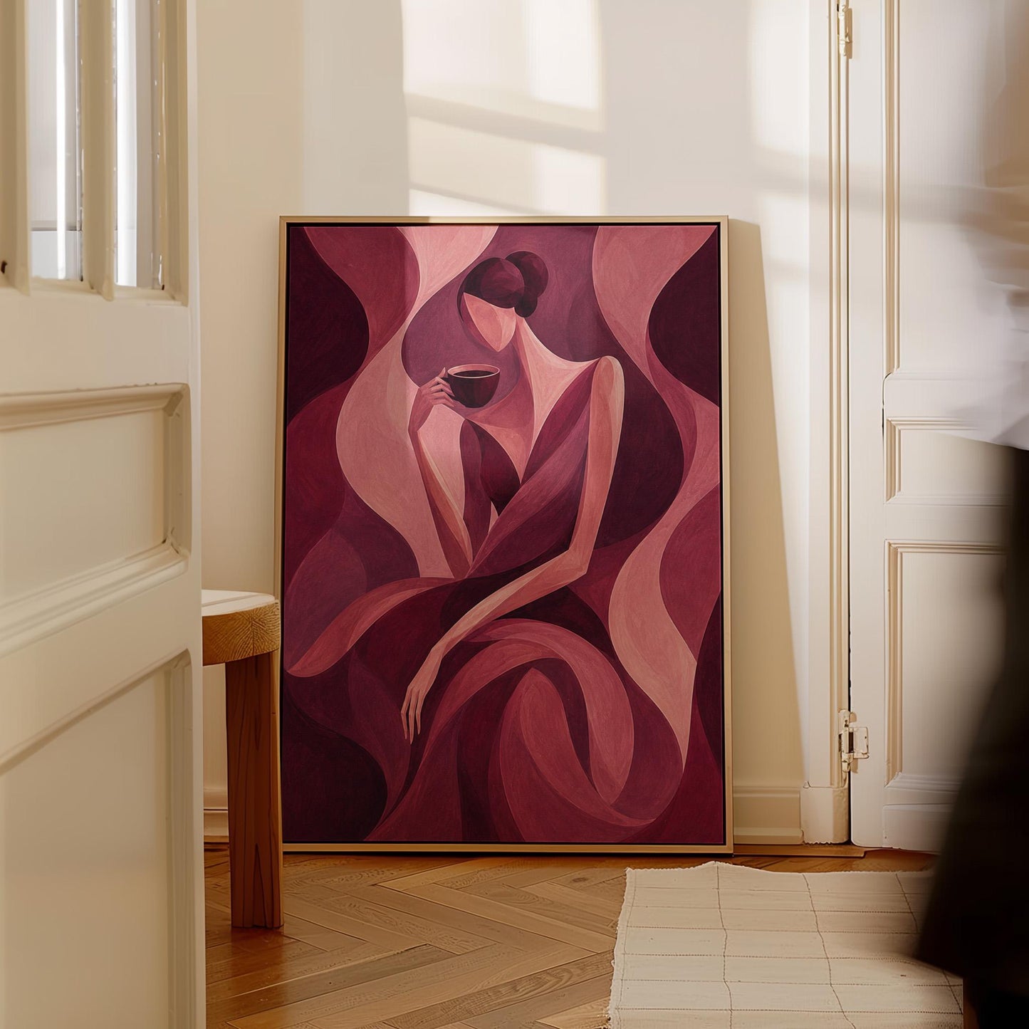 Woman sipping coffee among soft burgundy waves, canvas wall art on a quiet wall in a considered interior