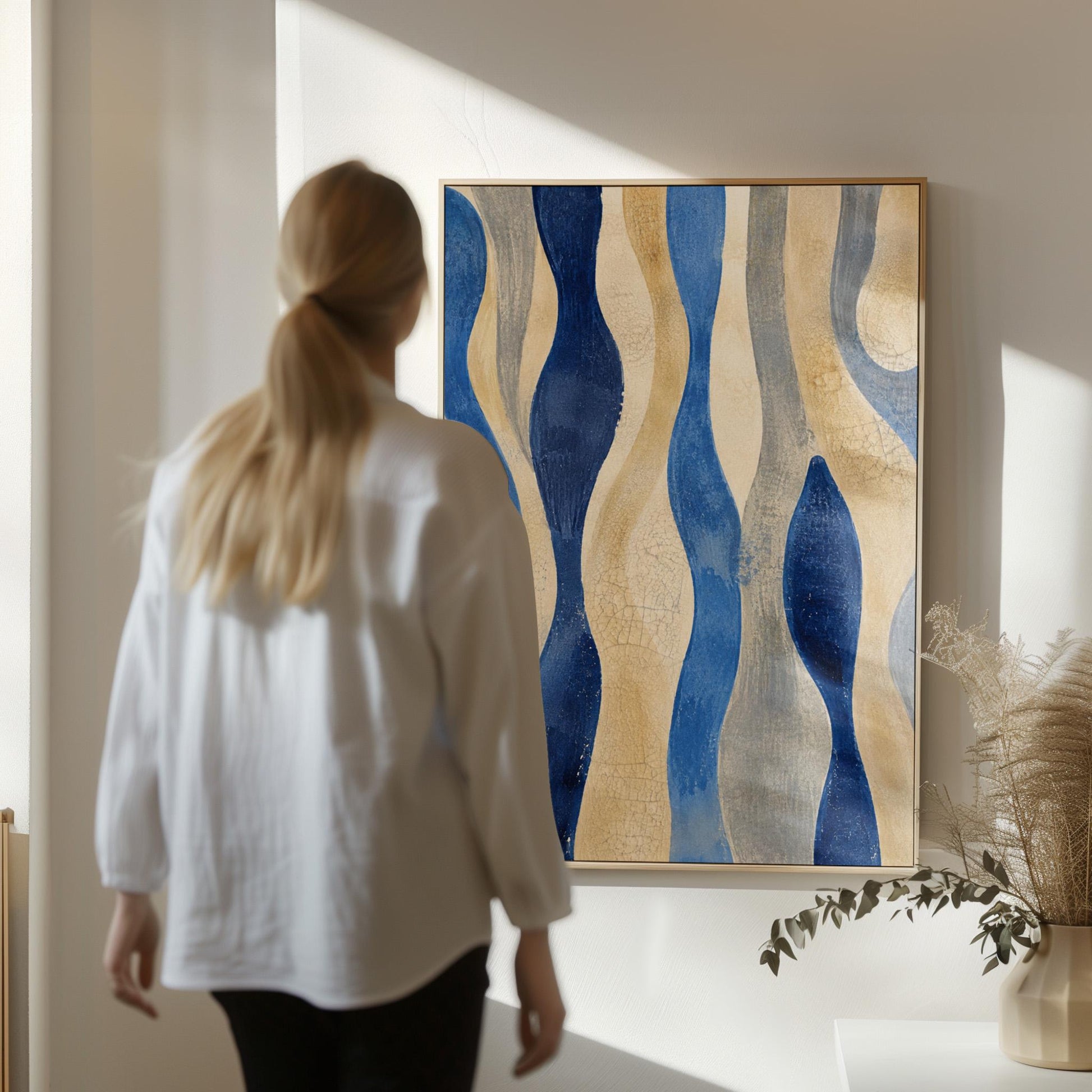 Vertical flowing wave bands in indigo and cream, canvas wall art presented in a light, minimal room