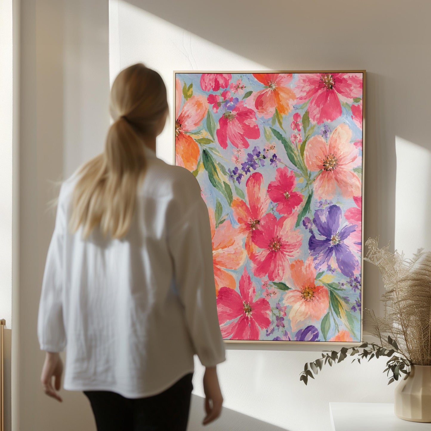 Vivid pink and purple watercolor blooms on light blue, canvas print displayed on a neutral wall in a styled interior