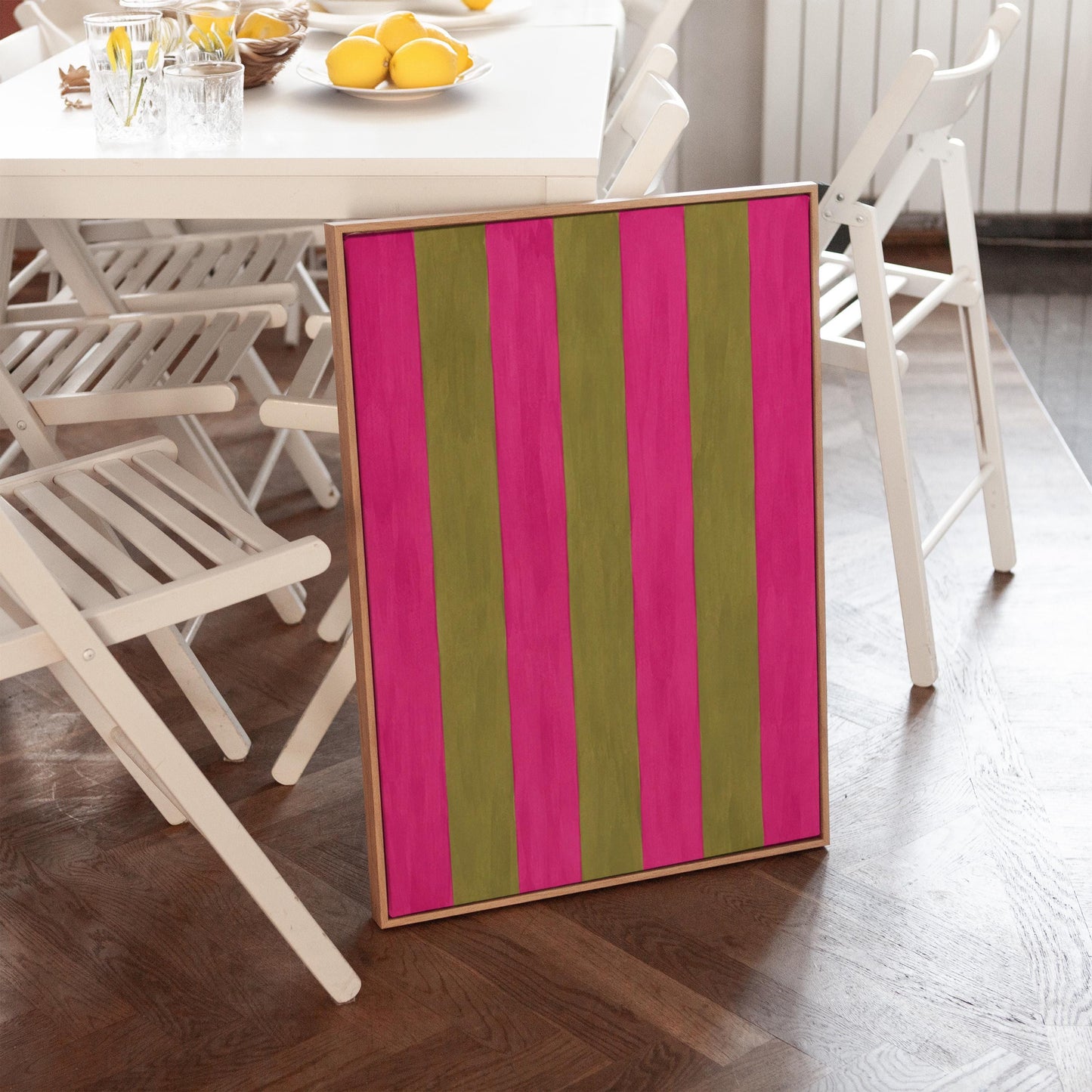 Bold vertical stripes in hot pink and olive green, canvas wall art hanging in a calm, modern living space