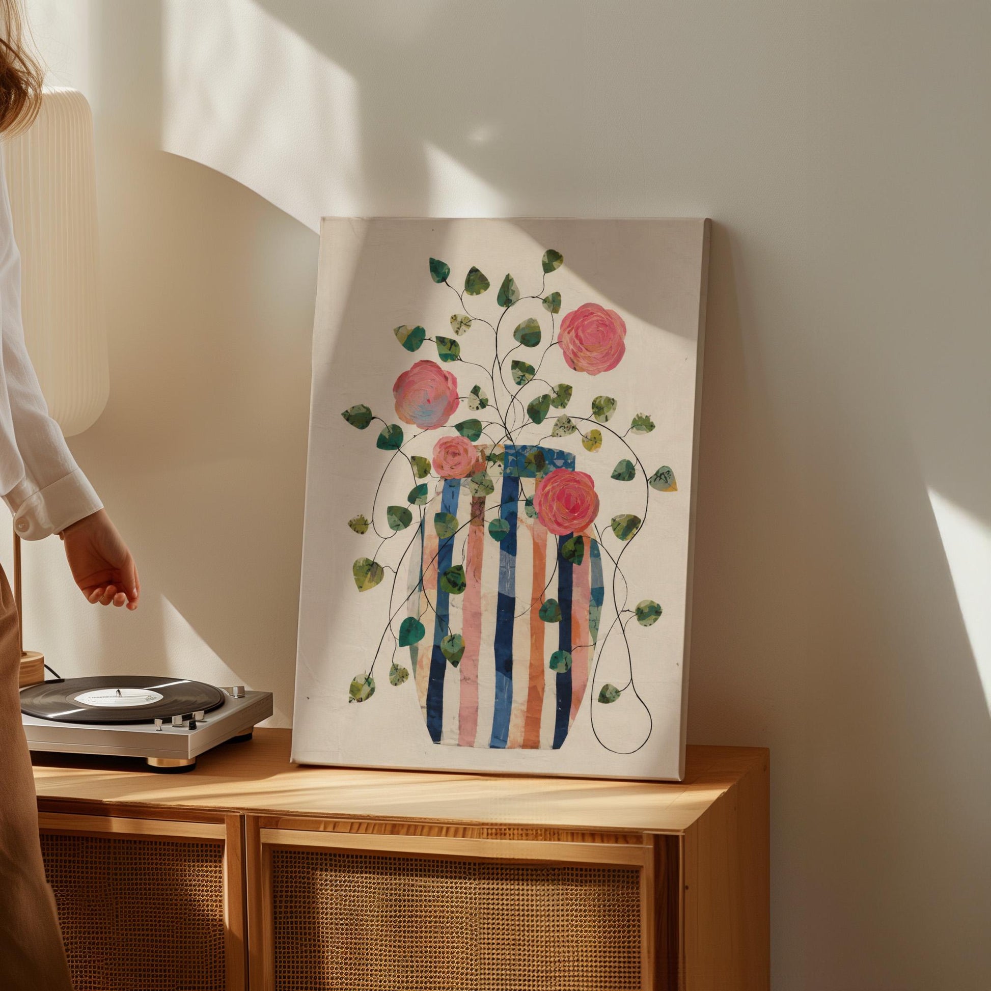 Climbing roses around a striped collage vase, canvas wall art presented in a light, minimal room