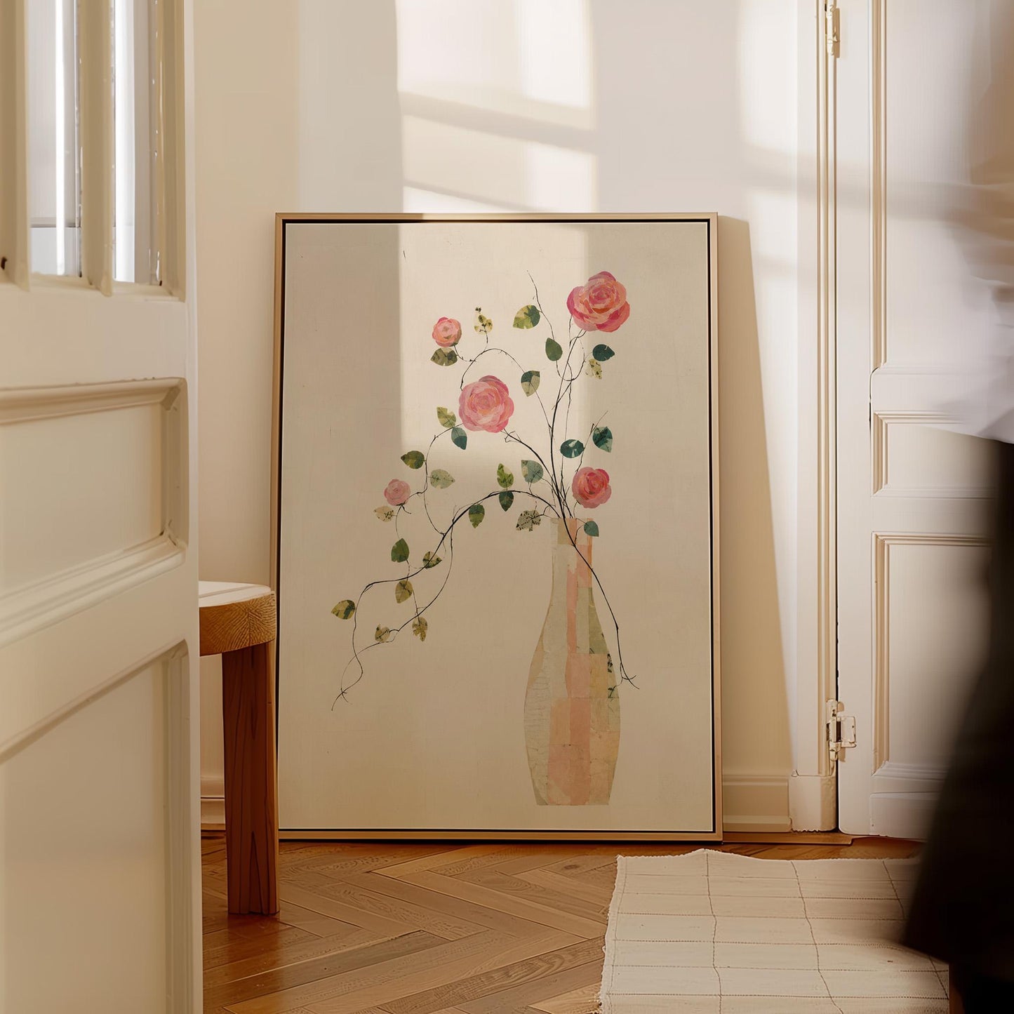 Single rose with trailing vine in slim vase, canvas print displayed on a neutral wall in a styled interior