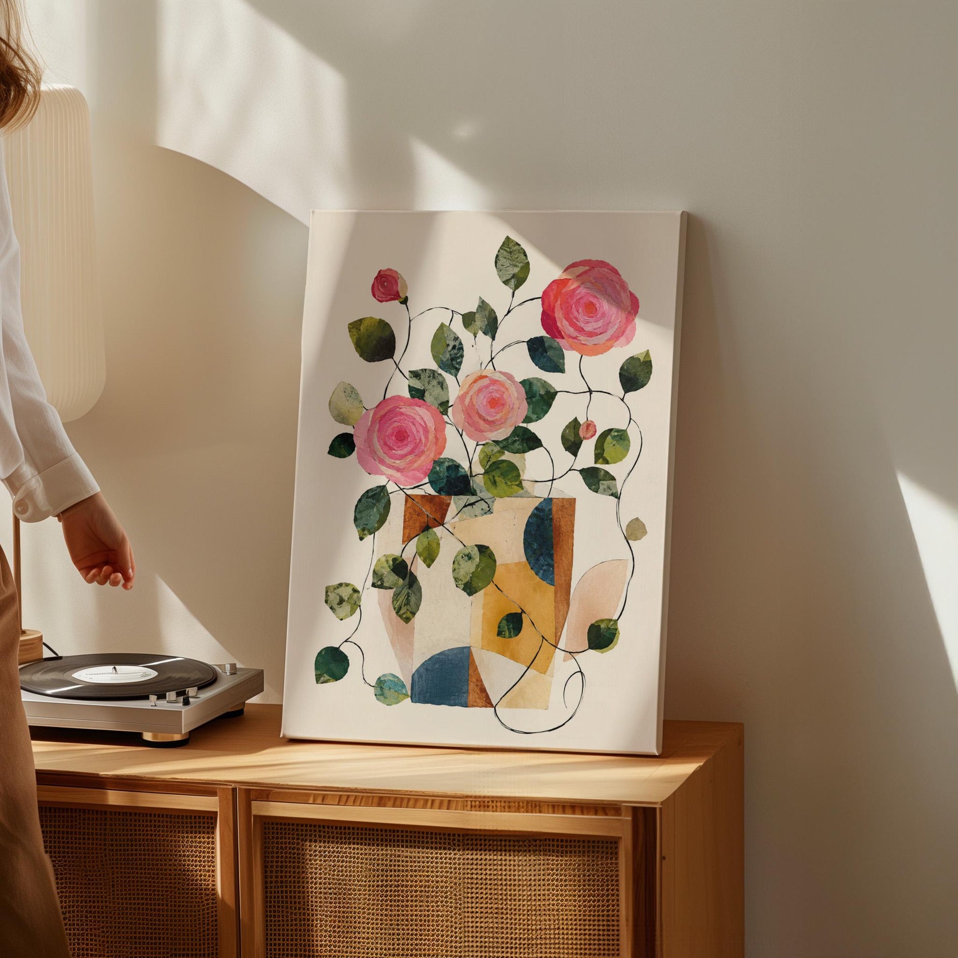 Lush roses spilling from geometric collage vase, canvas print seen in a warm interior with natural light