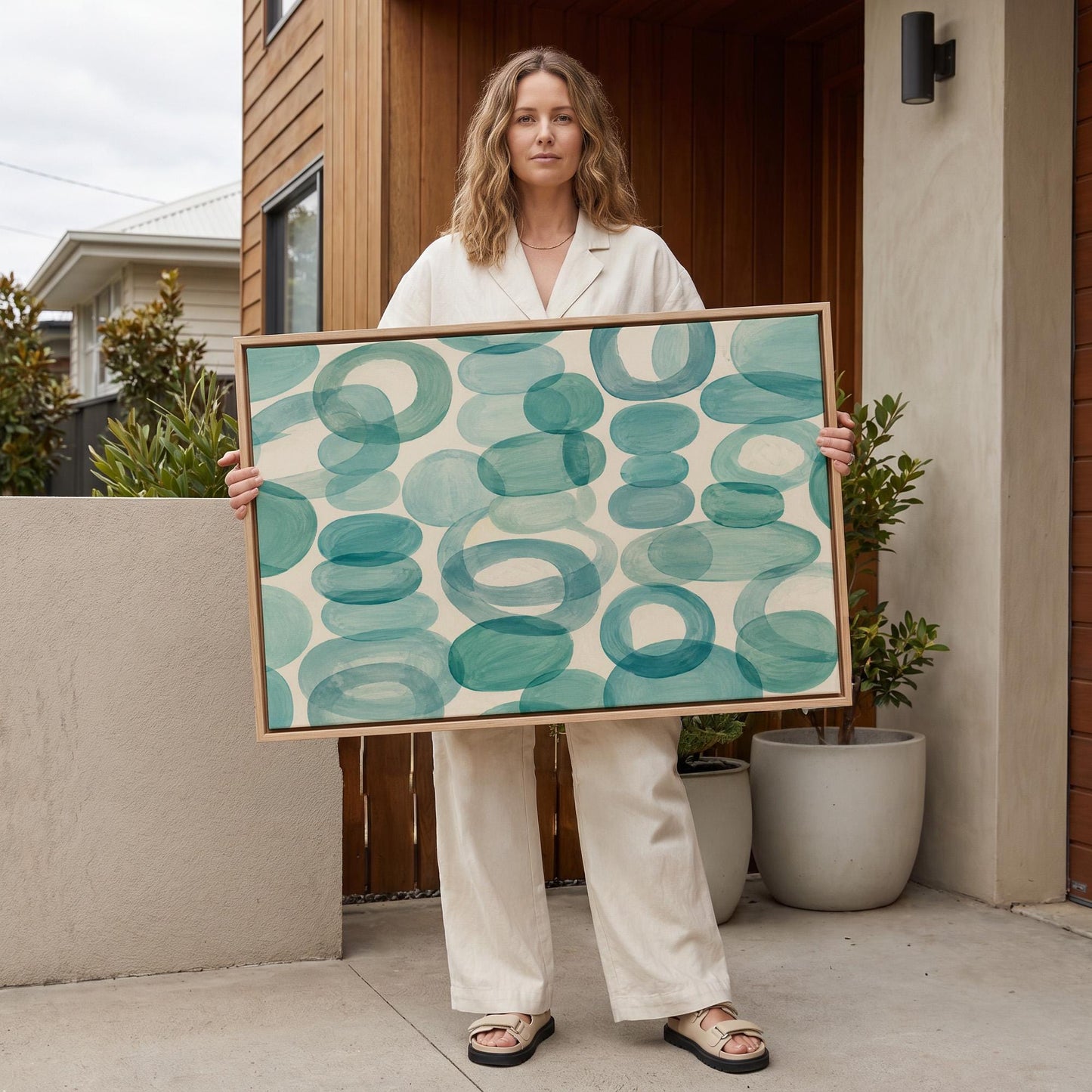 Overlapping aqua rings rolling across horizontal frame, canvas wall art hanging in a calm, modern living space