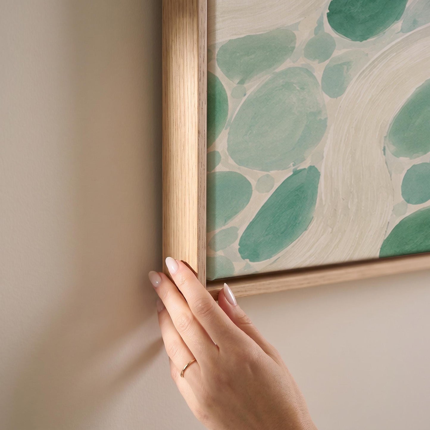 Aqua pebbles flowing like a stream horizontally, canvas print shown at full size in a light-filled bedroom