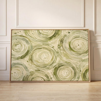 Swirling sage green ring circles, canvas print held up against a sunlit bedroom wall