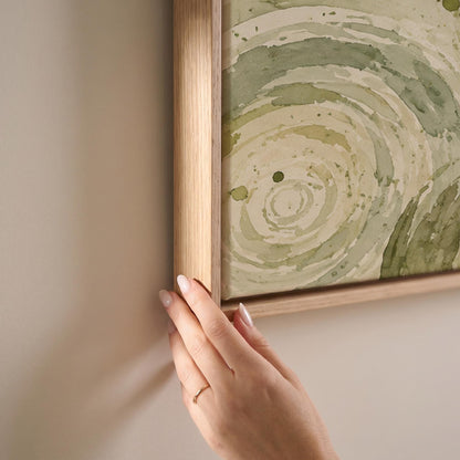 Swirling sage green ring circles, canvas print shown at full size in a light-filled bedroom