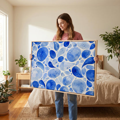 Watercolor blue pebbles spread across wide frame, canvas print styled against a soft white wall
