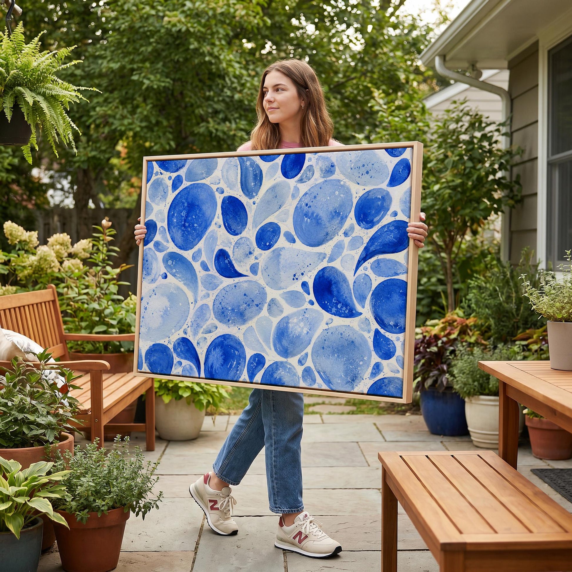 Watercolor blue pebbles spread across wide frame, canvas print seen in a warm interior with natural light