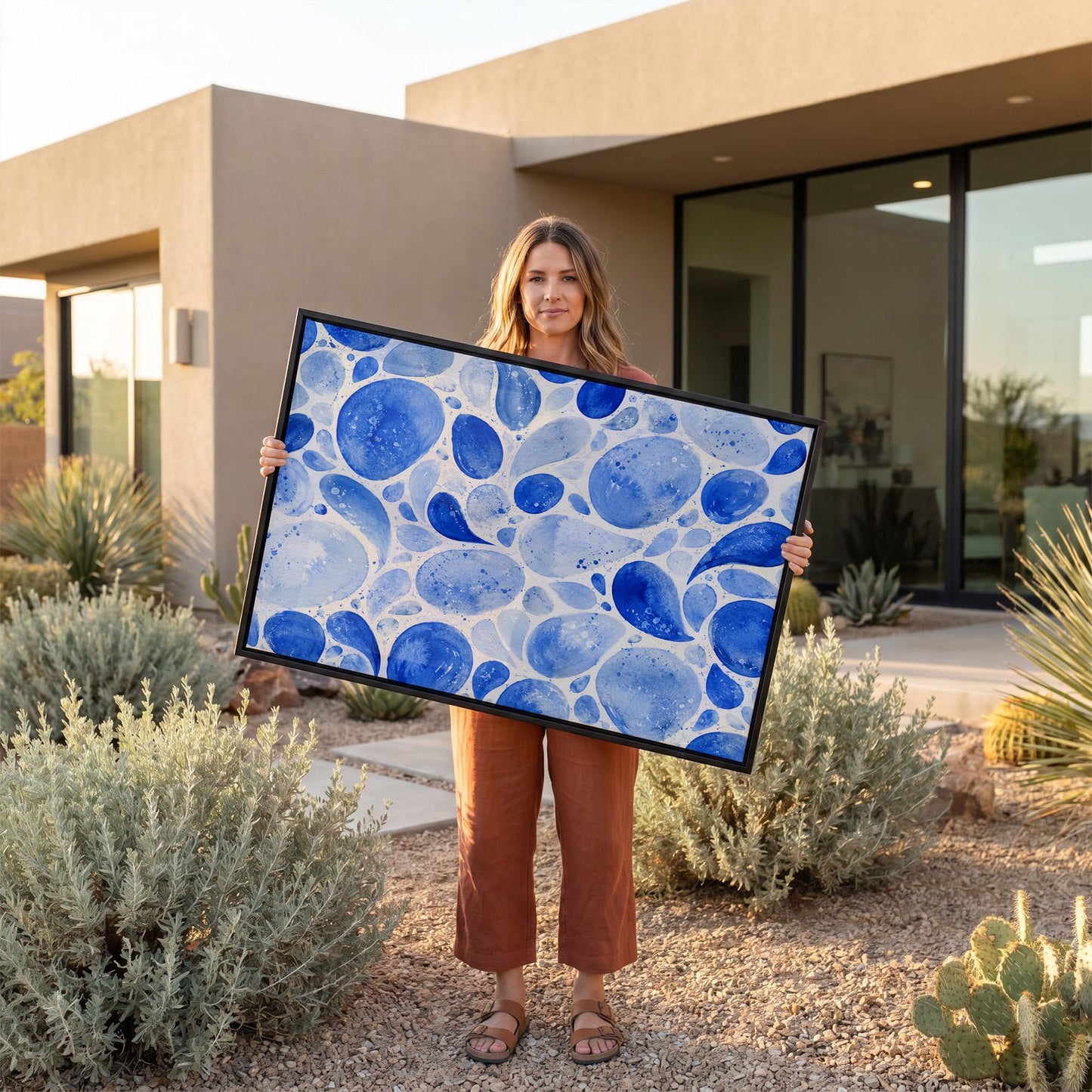 Watercolor blue pebbles spread across wide frame, canvas print presented in a light, minimal room