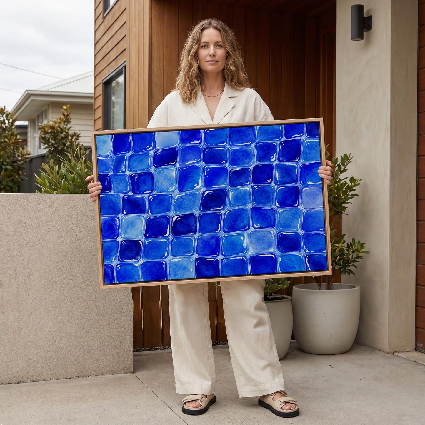 Deep sapphire mosaic tiles in wide grid, canvas wall art hanging in a calm, modern living space