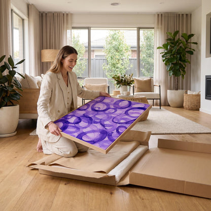 Swirling violet watercolor rings across wide frame, canvas wall art styled against a soft white wall