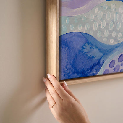 Meandering blue streams among dotted lavender islands, canvas print shown at full size in a light-filled bedroom