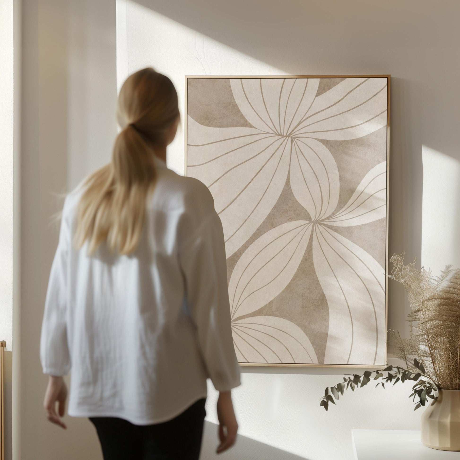 Abstract line drawing of oversized petals in cream and sand beige, canvas wall art hanging in a calm, modern living space