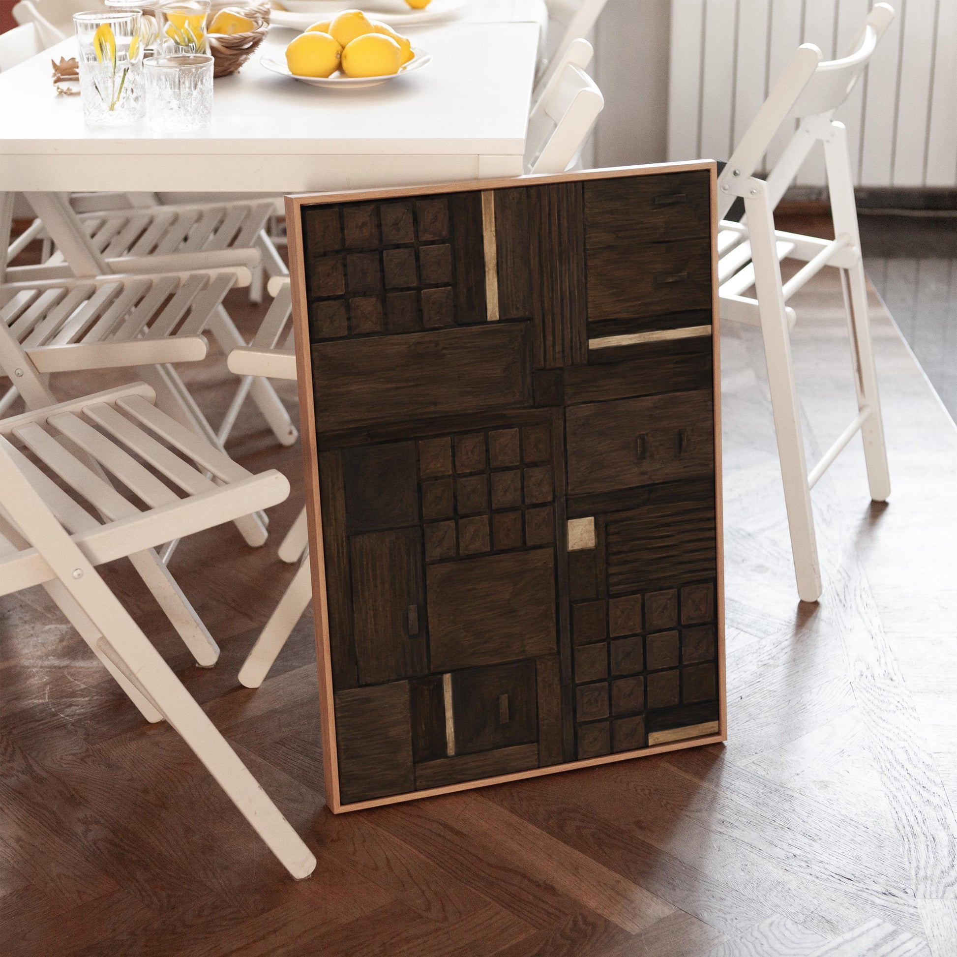 Dark espresso brown geometric patchwork with small gold accents, canvas wall art presented in a light, minimal room