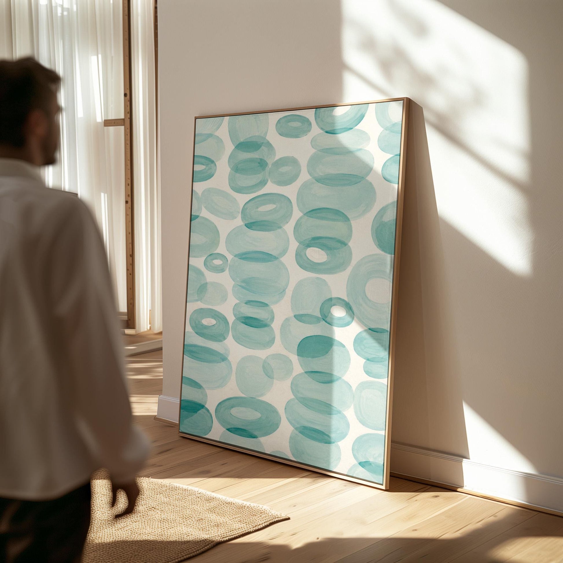 Watercolor rings and ovals in aqua and teal like sea glass, canvas print displayed on a neutral wall in a styled interior