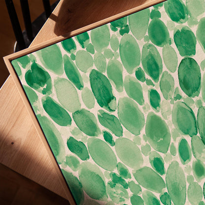 Dense watercolor pebble shapes in mint to emerald green, canvas print in a warm, minimally styled interior