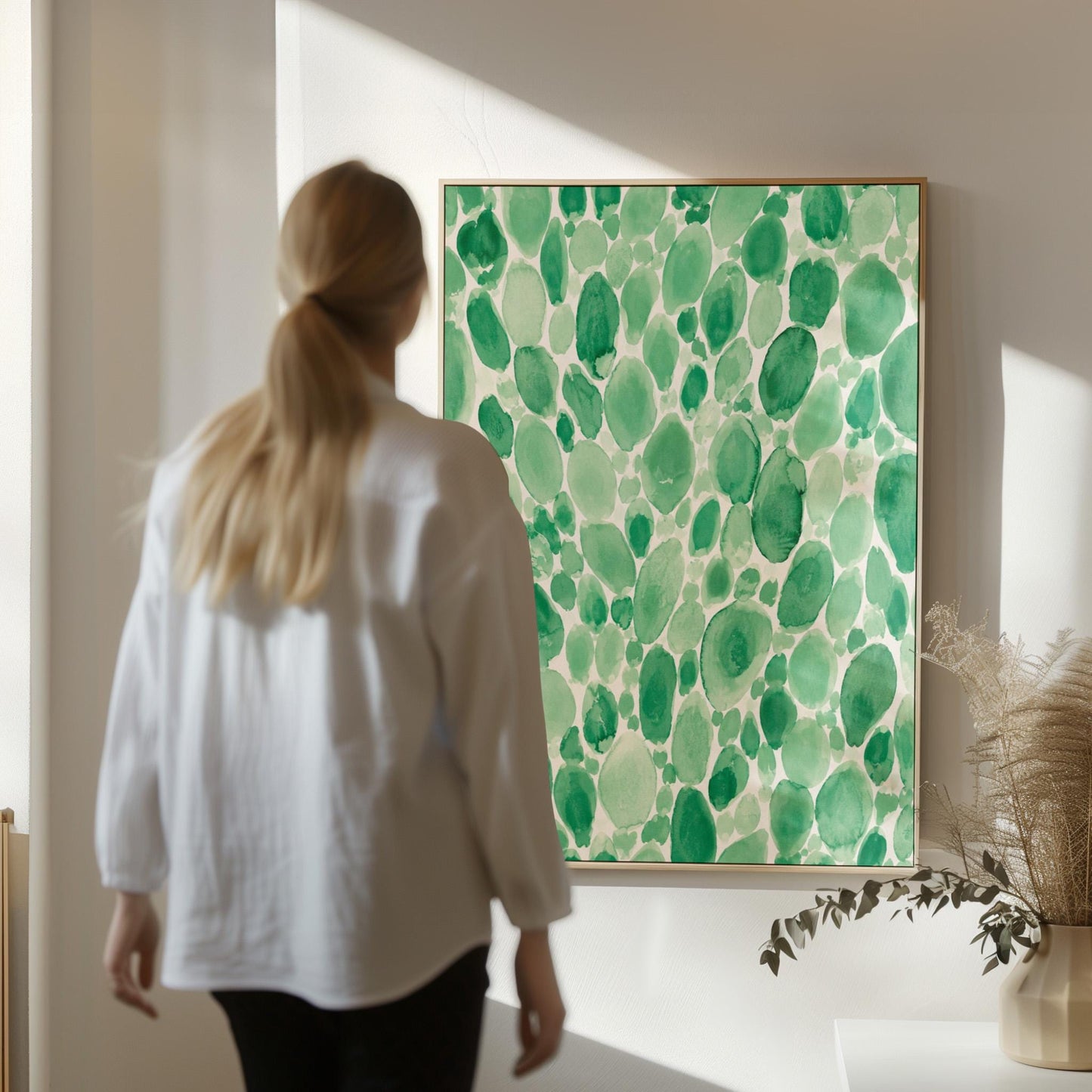Dense watercolor pebble shapes in mint to emerald green, canvas print styled against a soft white wall