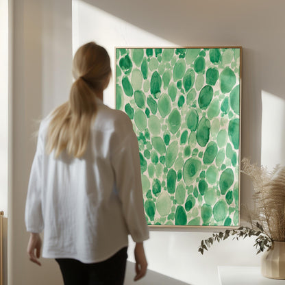 Dense watercolor pebble shapes in mint to emerald green, canvas print styled against a soft white wall
