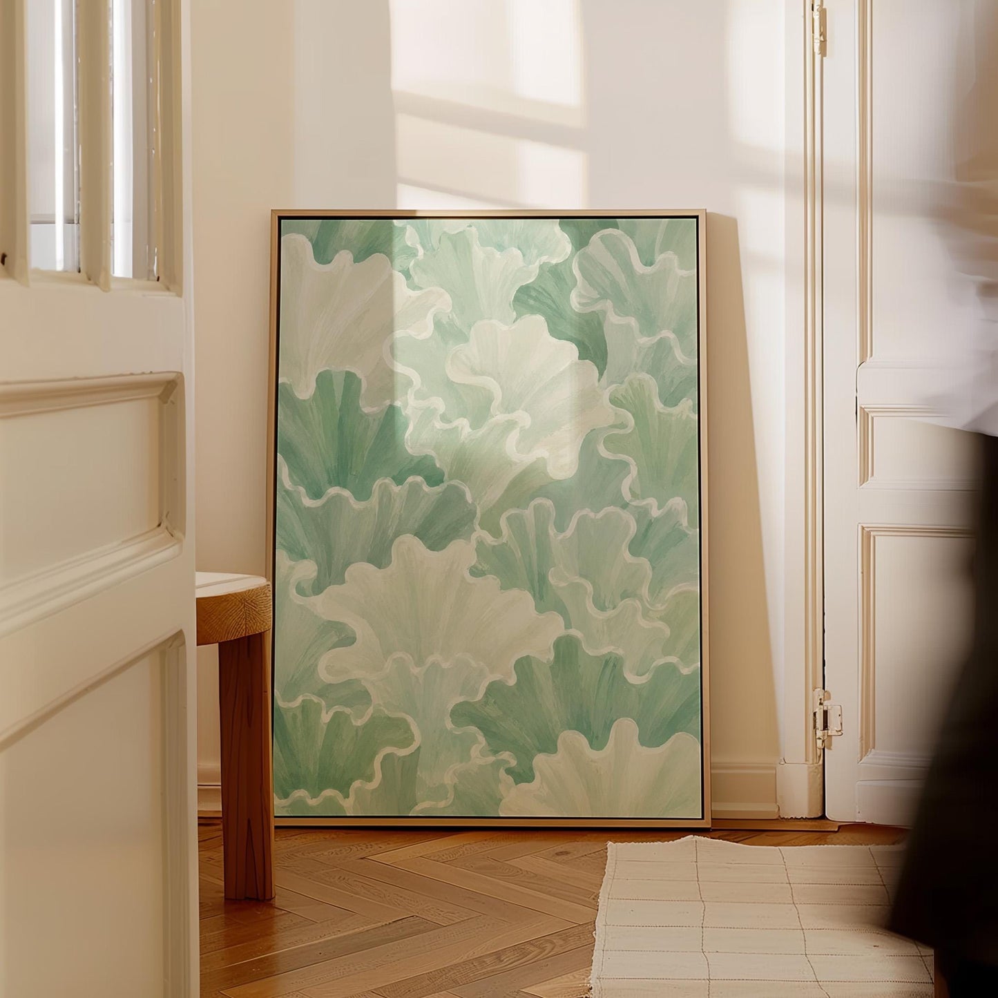 Fan shaped leafy forms in soft sage green watercolor, canvas print on a quiet wall in a considered interior