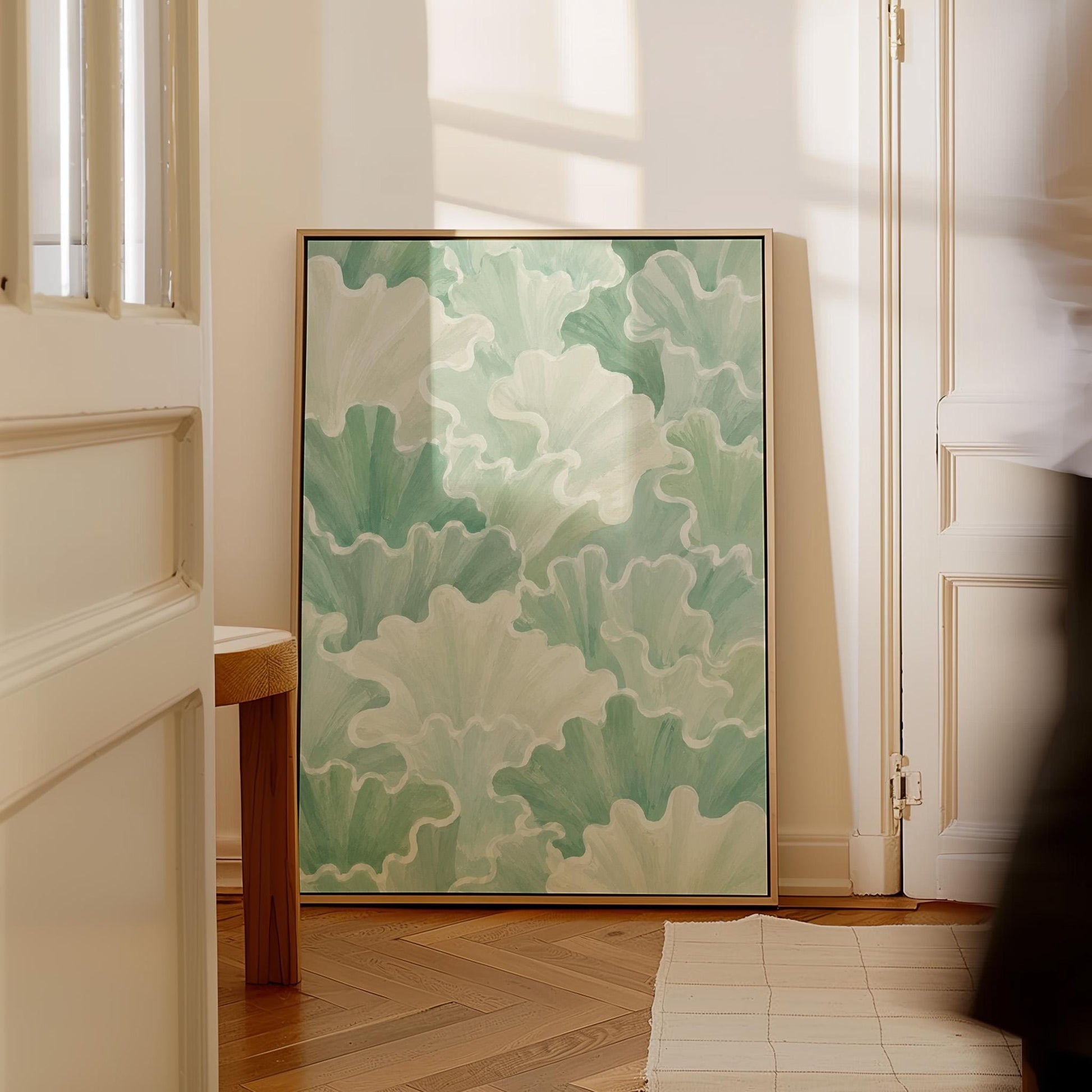 Fan shaped leafy forms in soft sage green watercolor, canvas print on a quiet wall in a considered interior